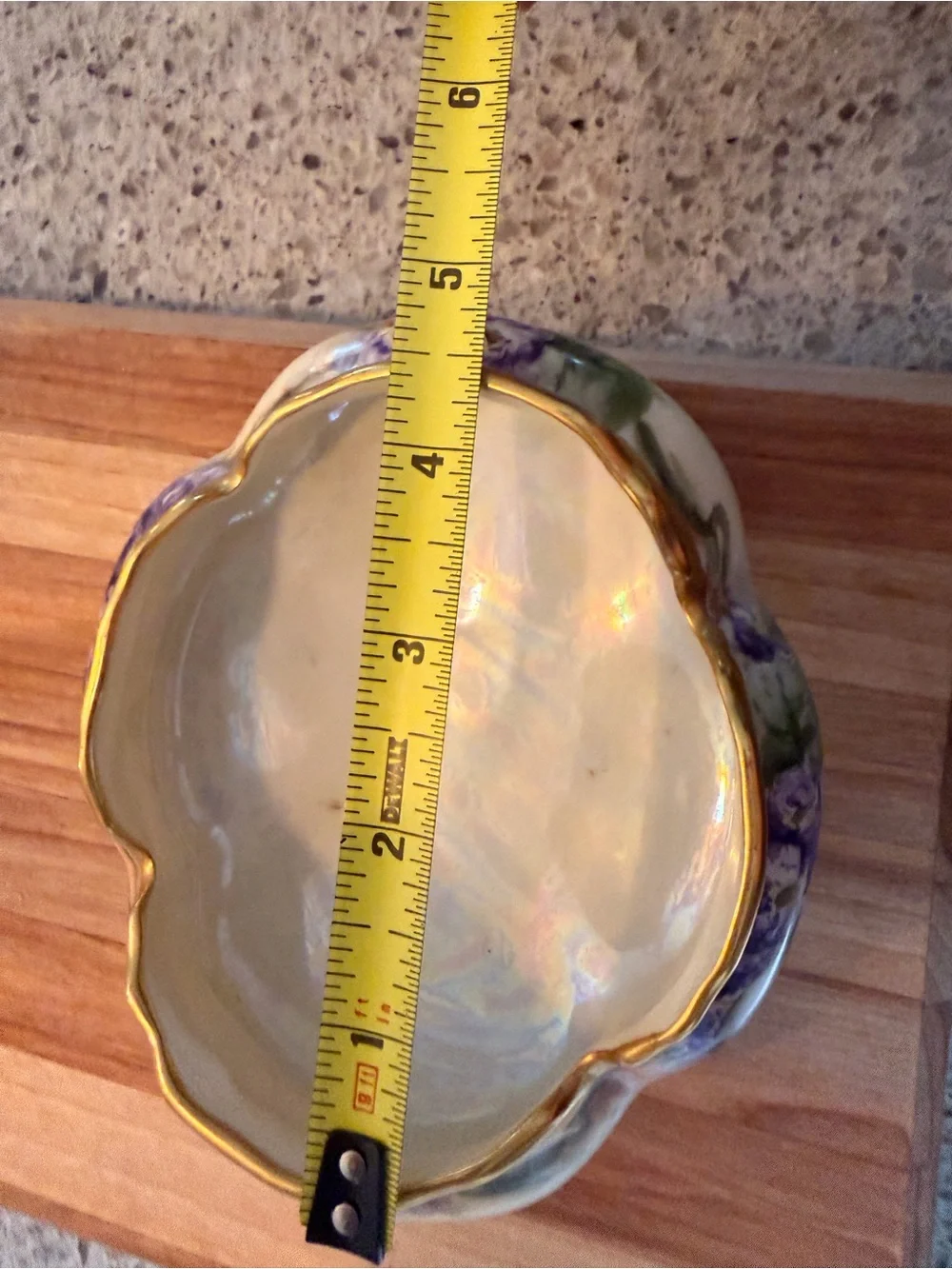 A hand-painted porcelain footed bowl with gilded rim and floral decoration.